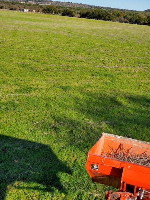 A lawn mower is sitting in the middle of a lush green field.