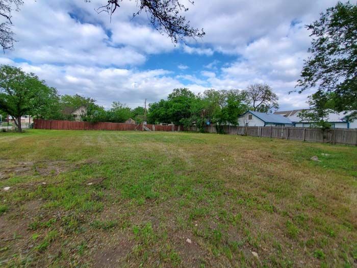 A large grassy field with a fence in the background