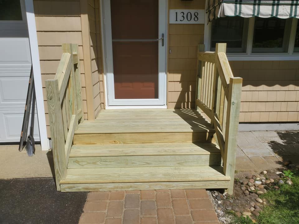 A front entryway featuring a wooden porch with two steps, handrails on both sides, and a white door numbered 1308.