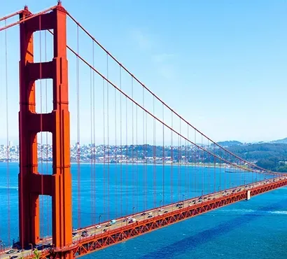 Golden Gate Bridge spanning across a blue bay under a clear sky.
