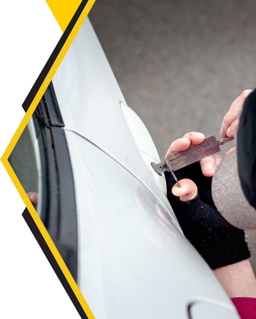 A person is opening a car door with a key