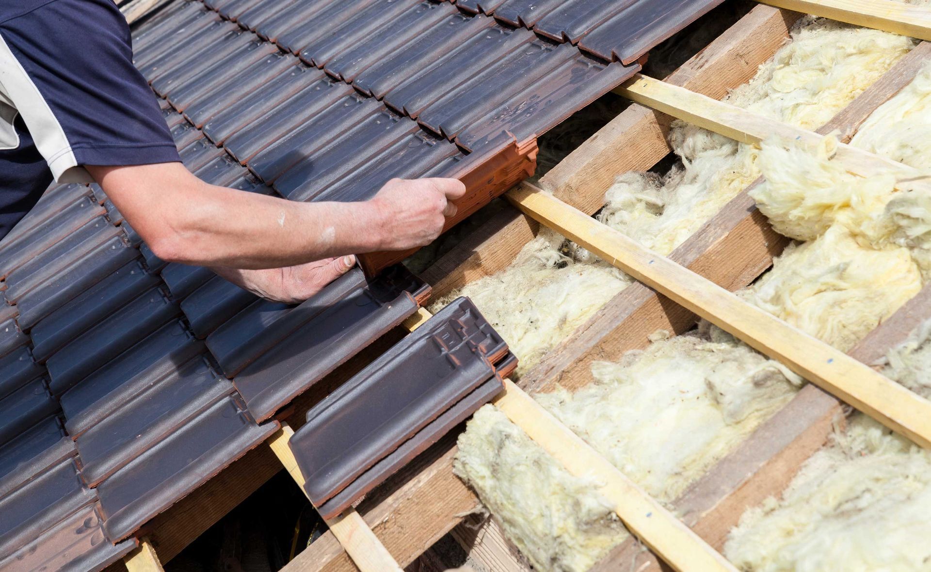 Roofer showcasing roofing services while laying tiles on a residential roof.