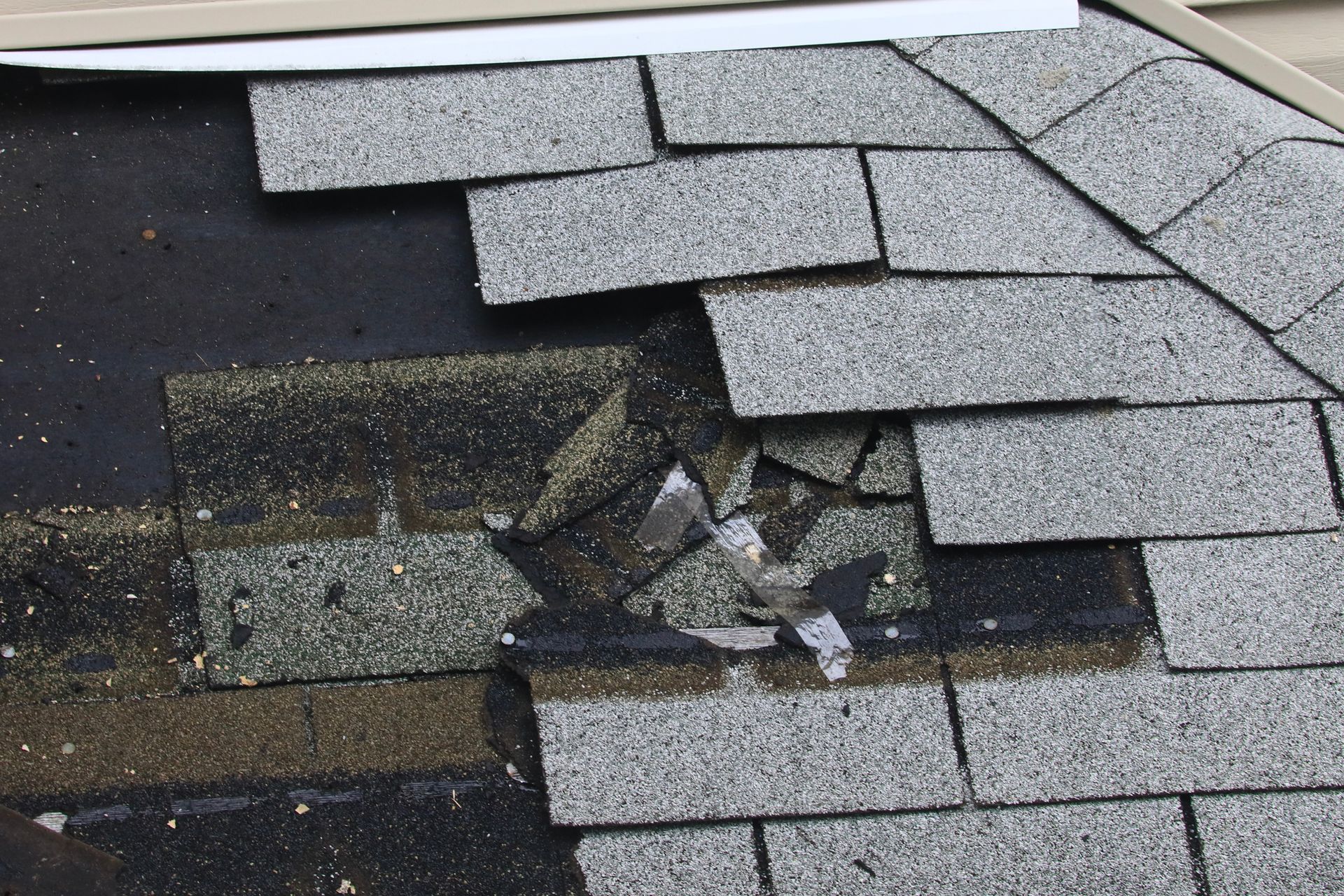 Damaged roof shingles with cracks and missing pieces.