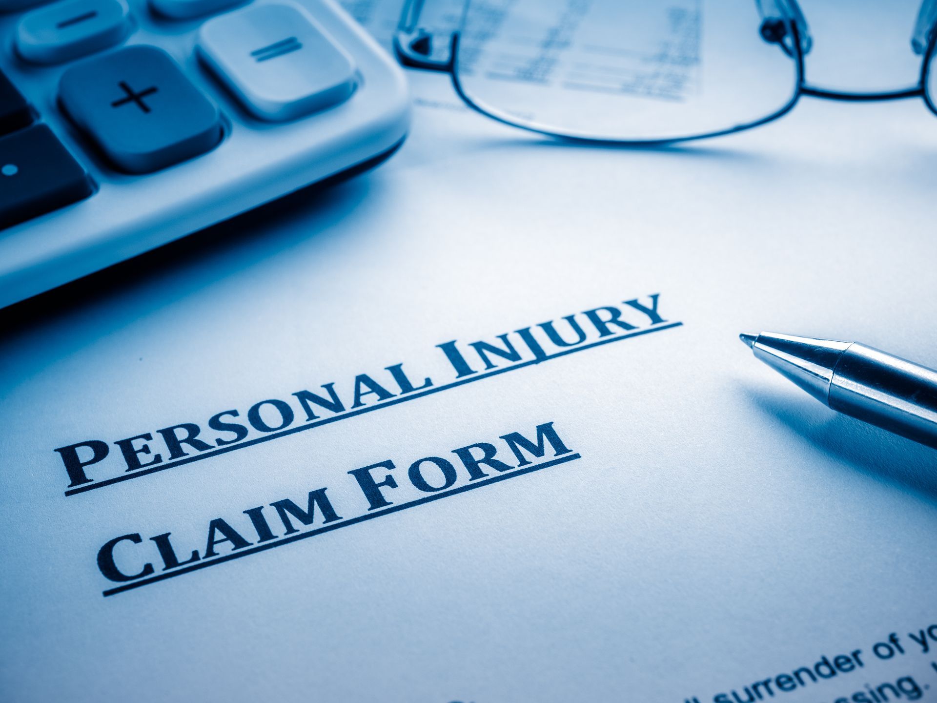 Personal injury claim document with pen and glasses, symbolizing legal process and documentation.