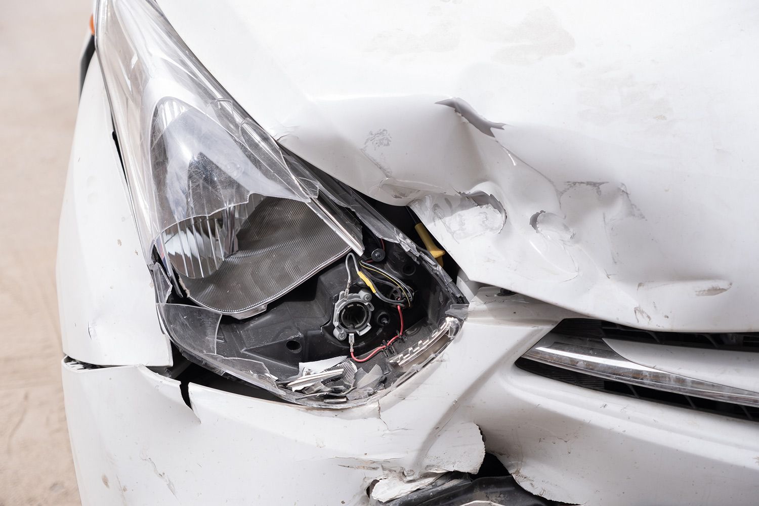 Damaged car headlight and front panel after a collision