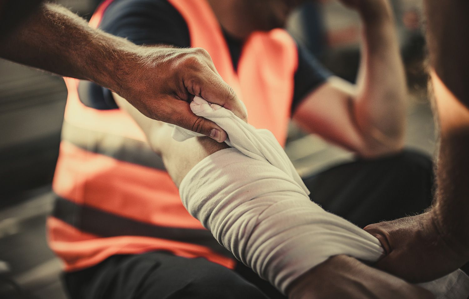 Person's arm being bandaged by another person