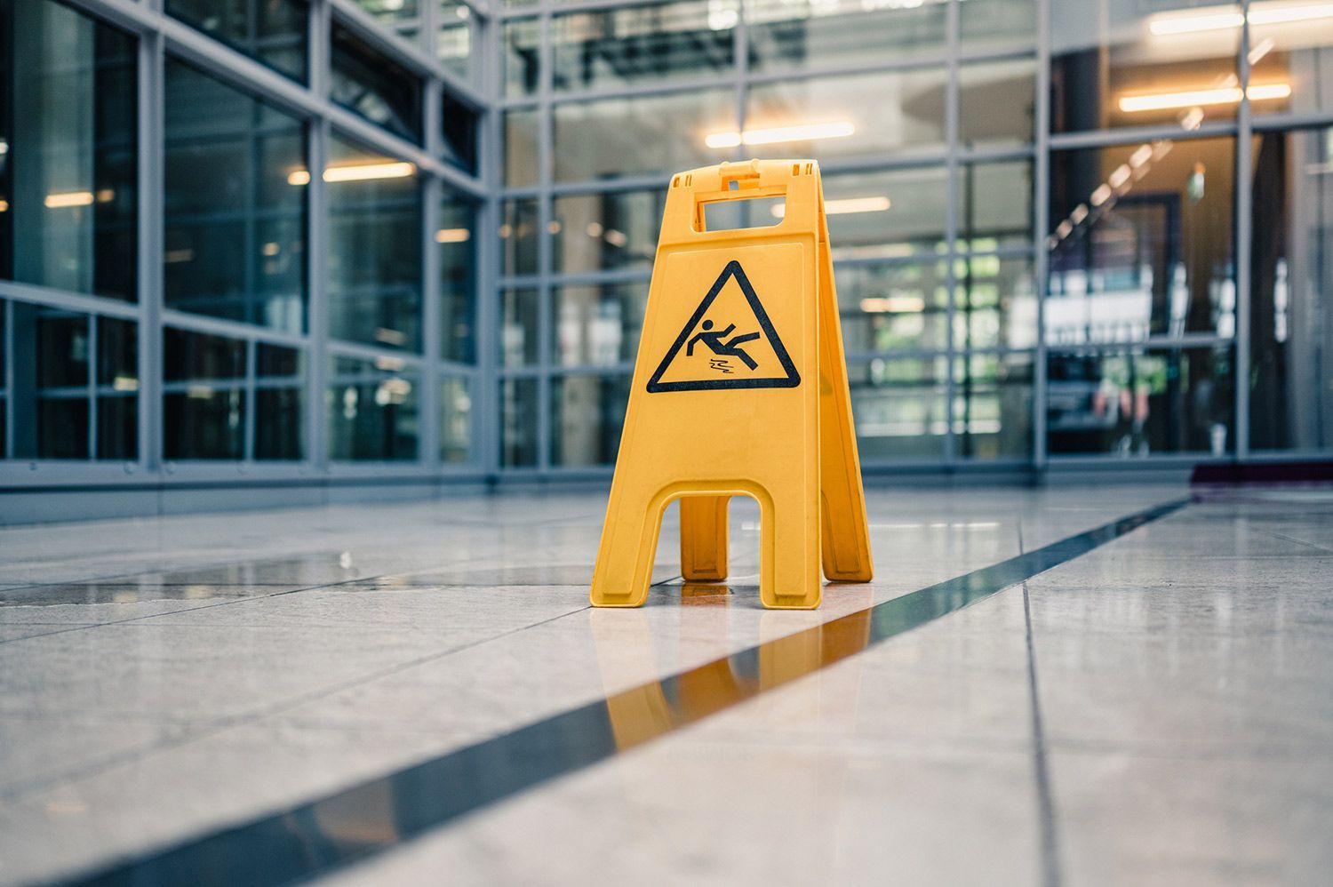 Yellow caution sign on wet floor in a building