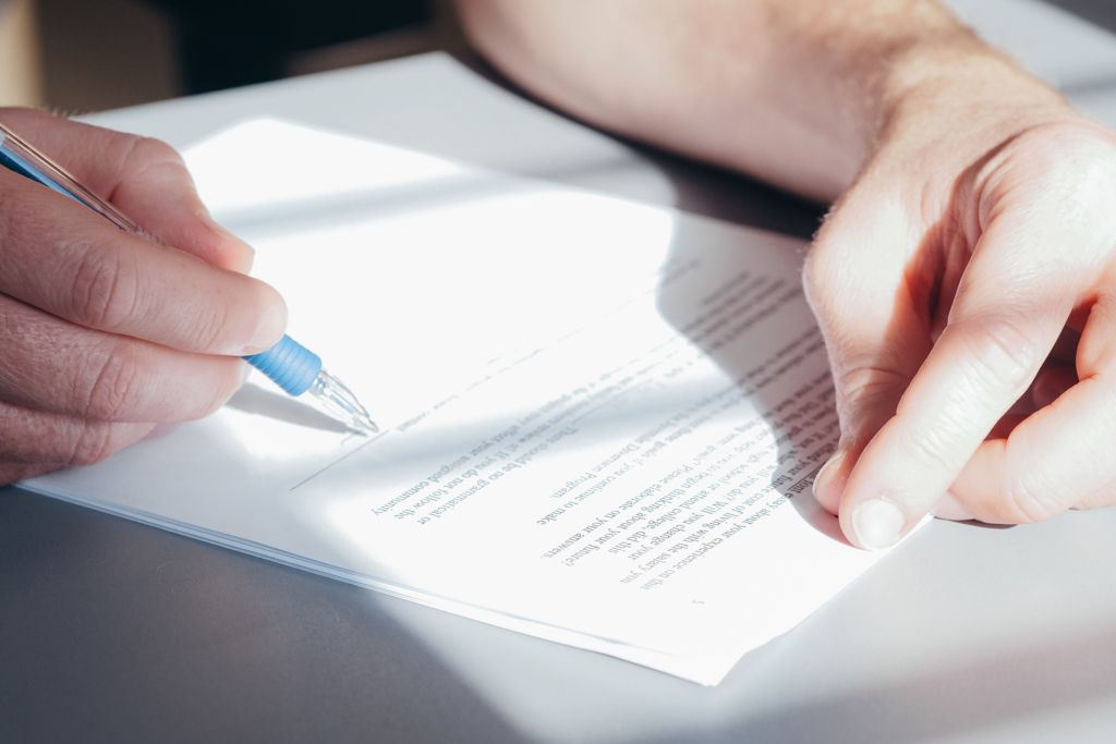 Person writing with a pen on a document