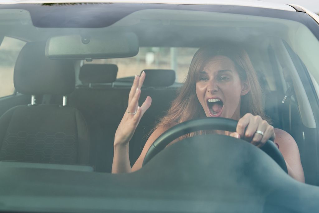 Woman in a car showing anger and frustration