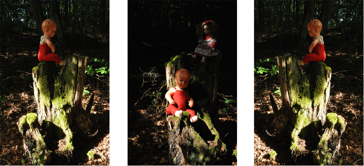 Fotografie der Künstlerin Benita von Wendt. Titel: Verborgen. Die Fotografie zeigt 3 identische männliche und 1 weibliche altmodische Puppe die auf Baumstämmen sitzen, ein Spiel aus Licht und Schatten setzt die Puppen in Szene, die Umgebung löst sich in der Dunkelheit auf. Die Fotoarbeit besteht aus 3 Fotografien die miteinander in Beziehung stehen.