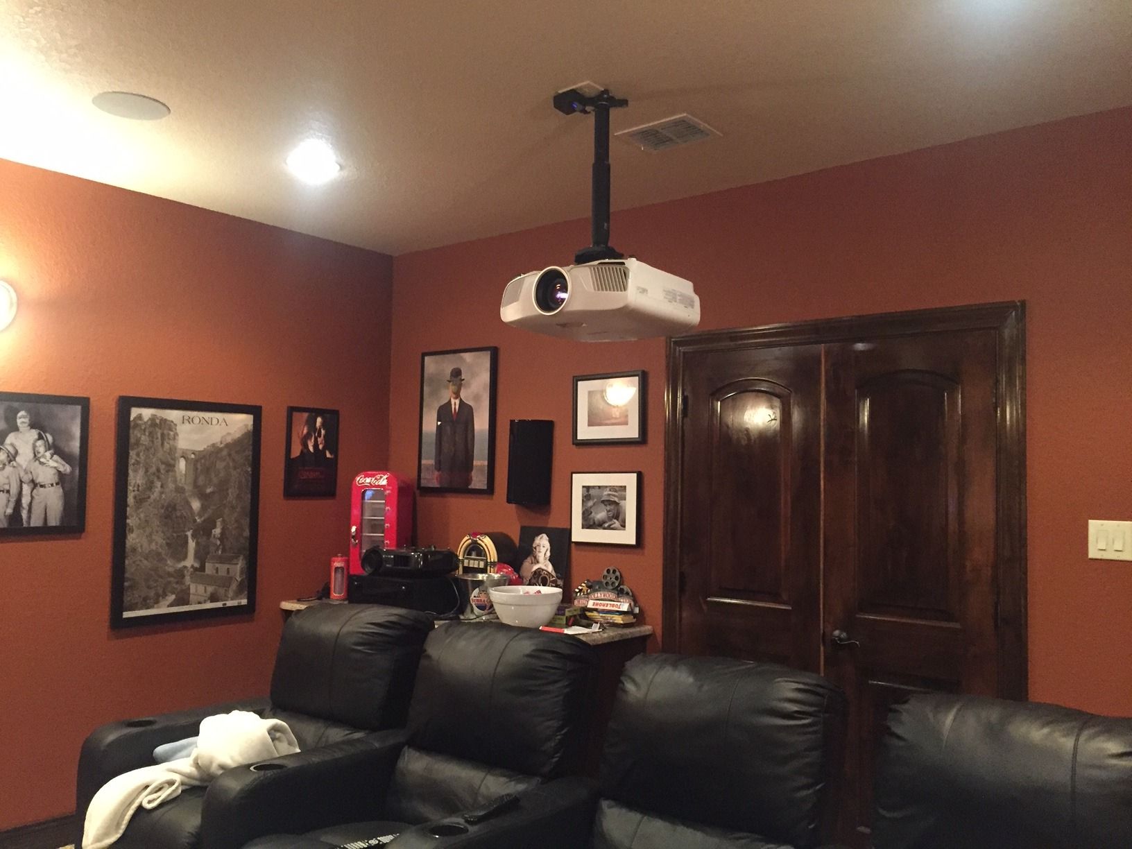 A home theater with a projector hanging from the ceiling