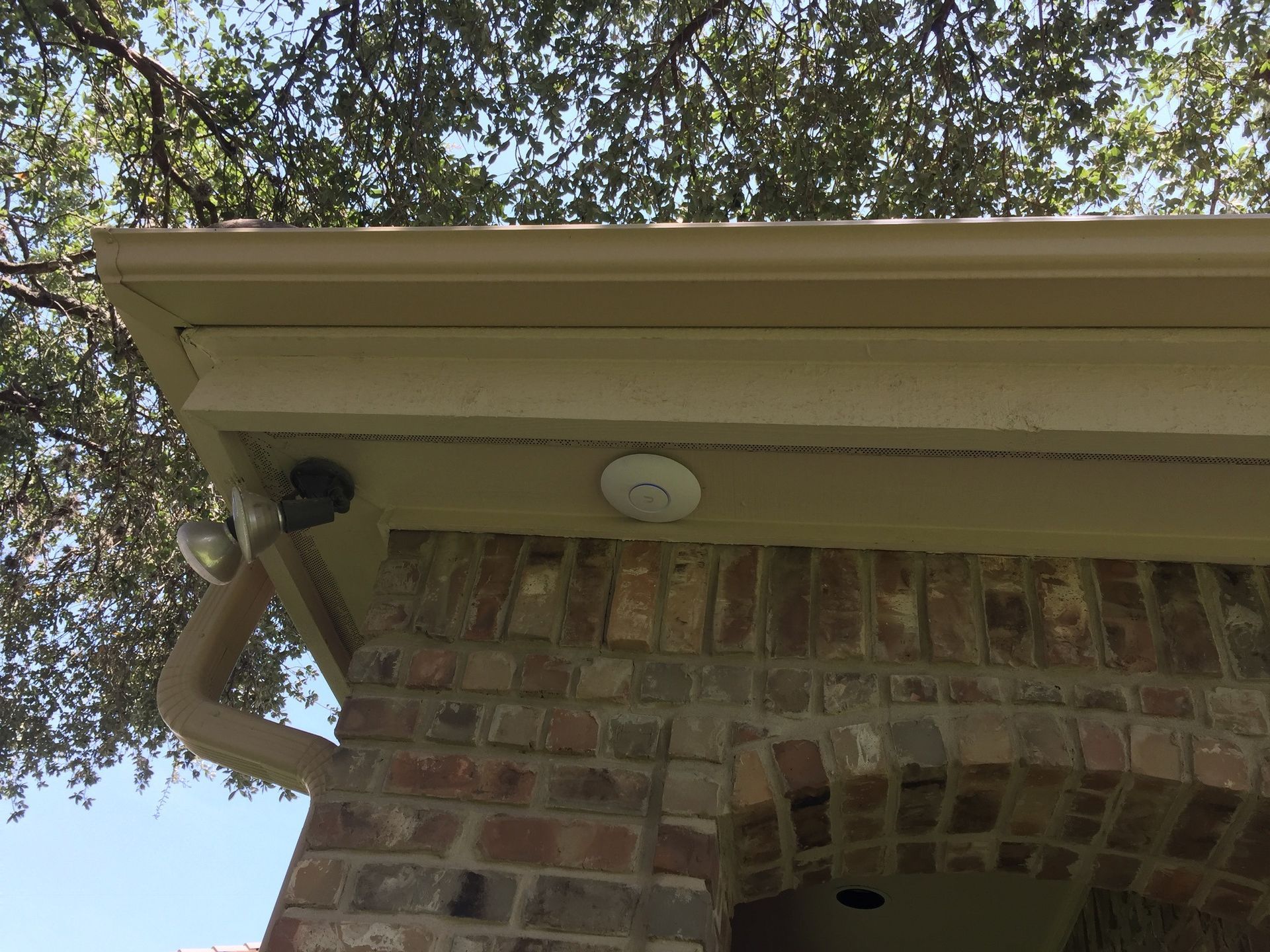 A brick building with a gutter and a light on the roof.