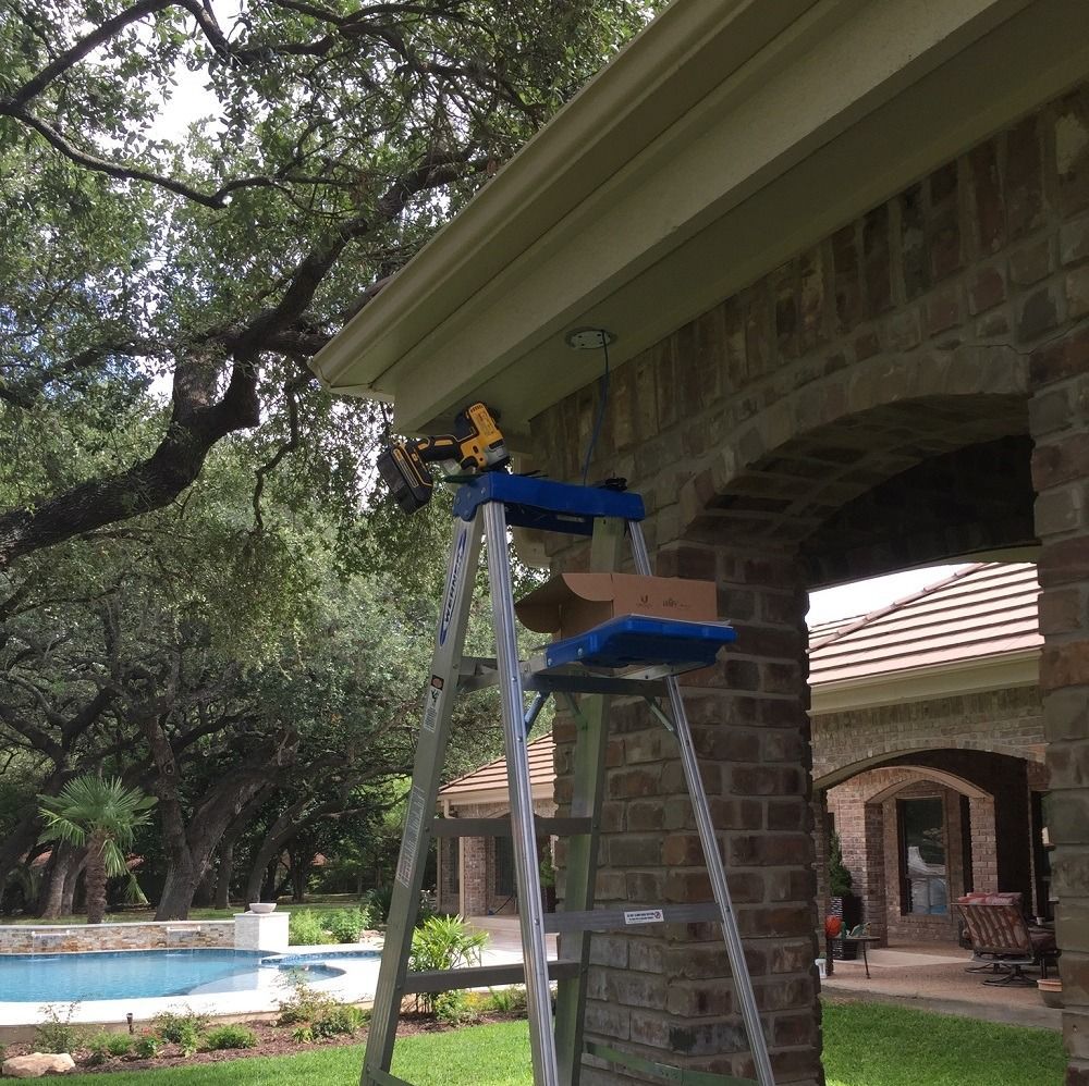 A ladder with a box on it is sitting under a brick archway