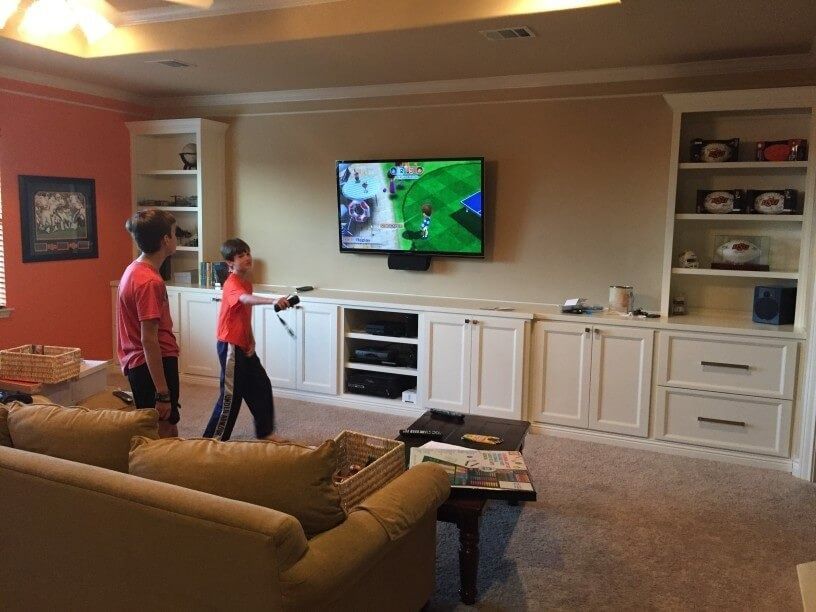 Two boys are playing a video game in a living room.