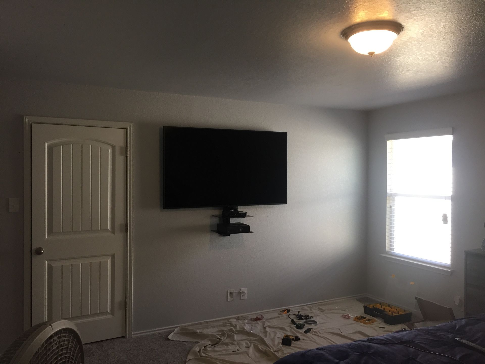 A bedroom with a flat screen tv mounted on the wall.