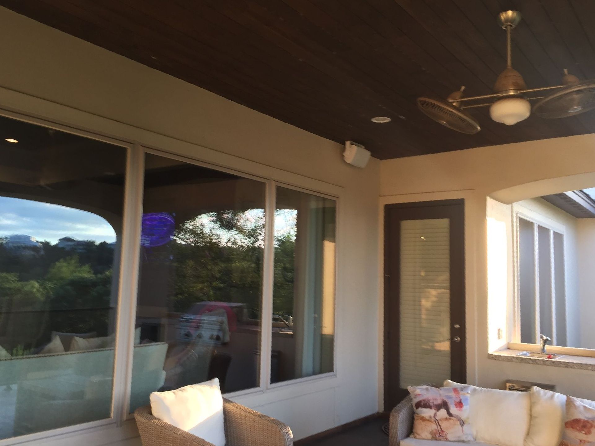 A living room with a couch , chairs , and a ceiling fan.