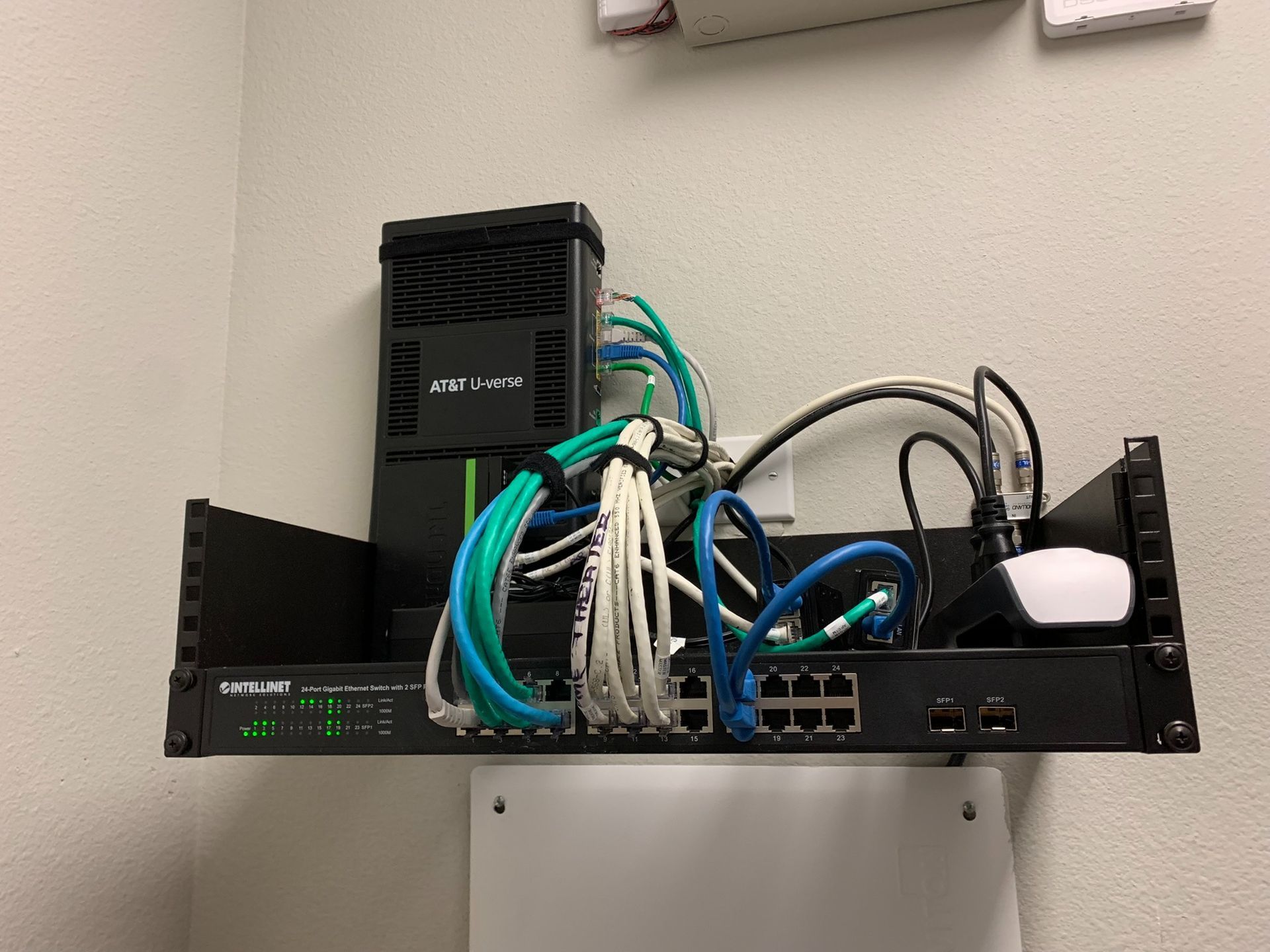 A bunch of wires are hanging from a rack on a wall.