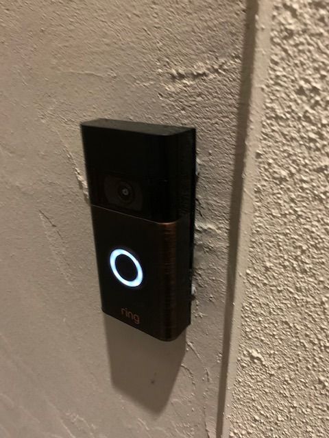 A ring doorbell is mounted on a white wall.