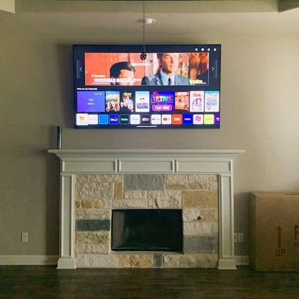 A flat screen tv is mounted above a fireplace