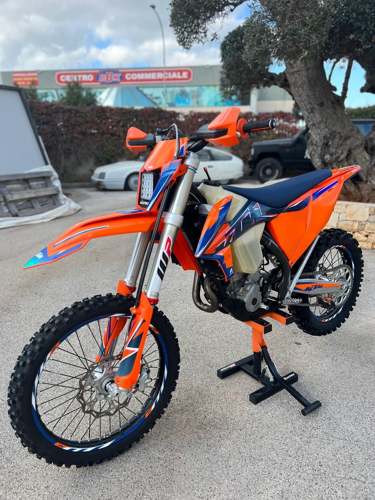 Motocicletta Honda Africa Twin rossa e bianca parcheggiata sul marciapiede con uno sfondo di cielo azzurro.