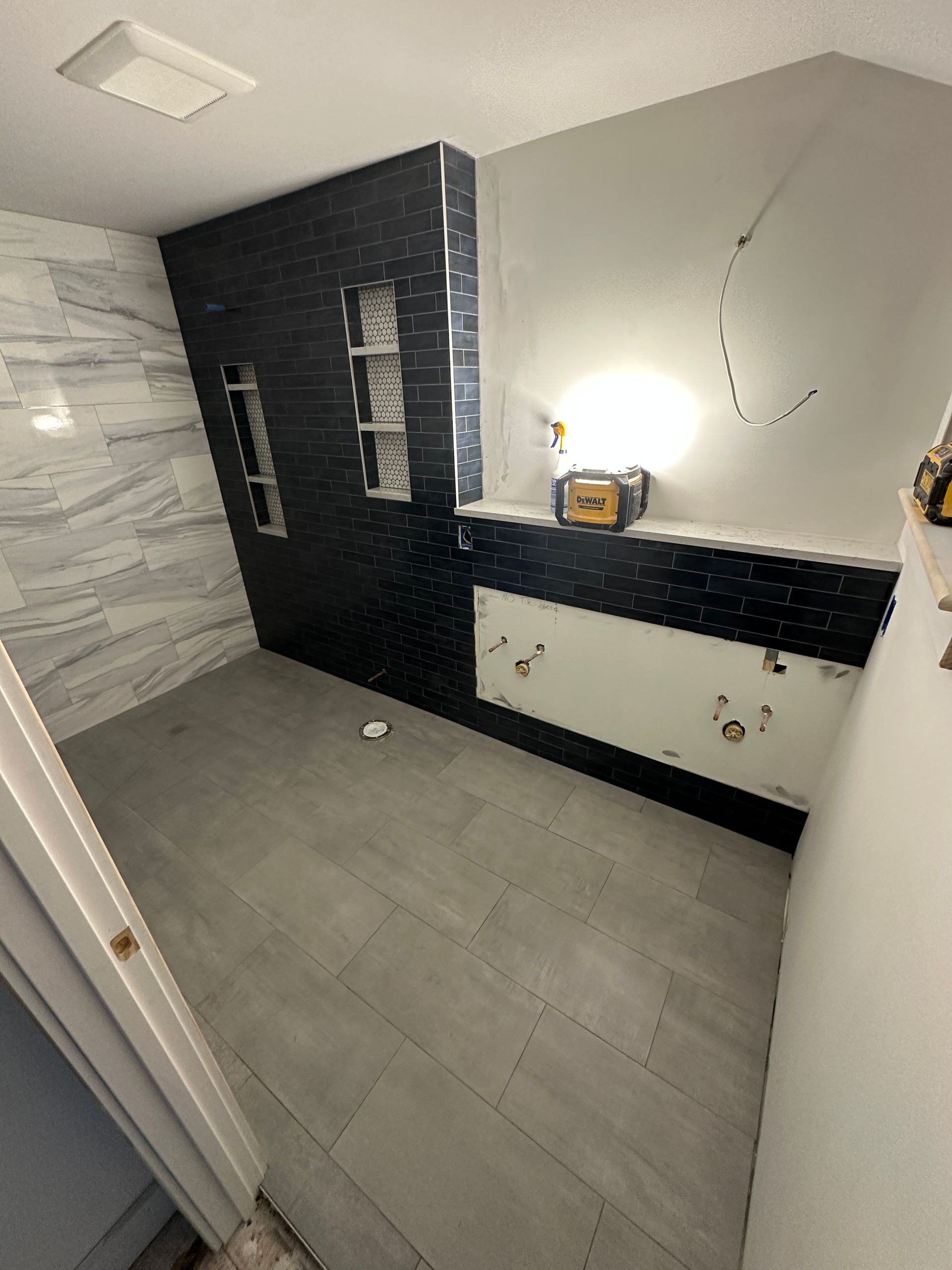 A bathroom with black and white tiles and a sink.