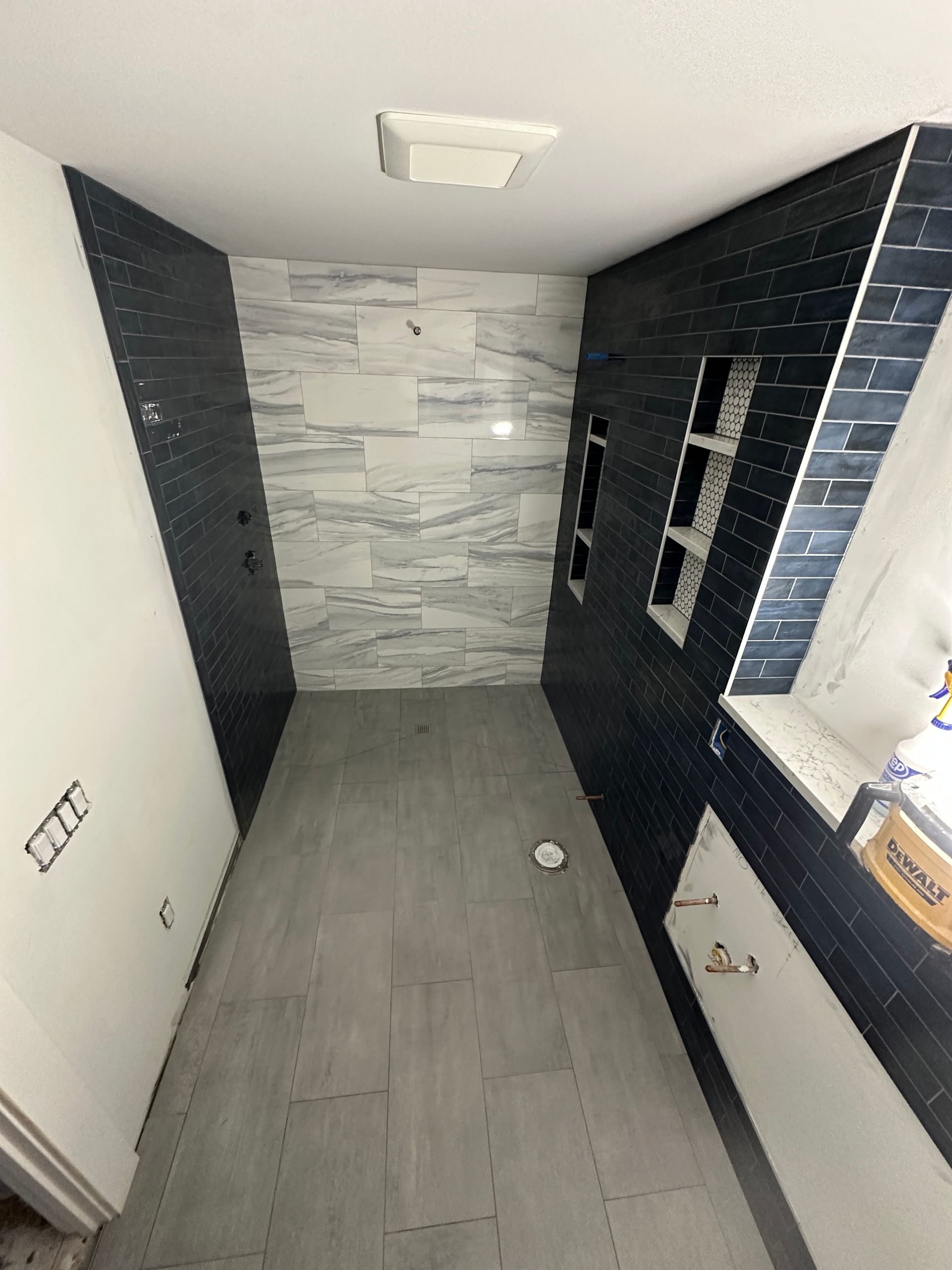 A bathroom with blue and white tiles and a window.