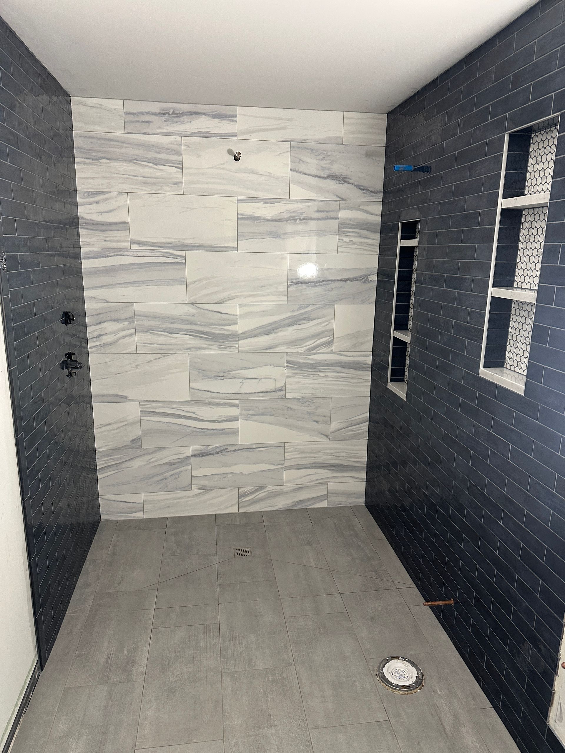 A bathroom with black and white tiles on the walls and floor