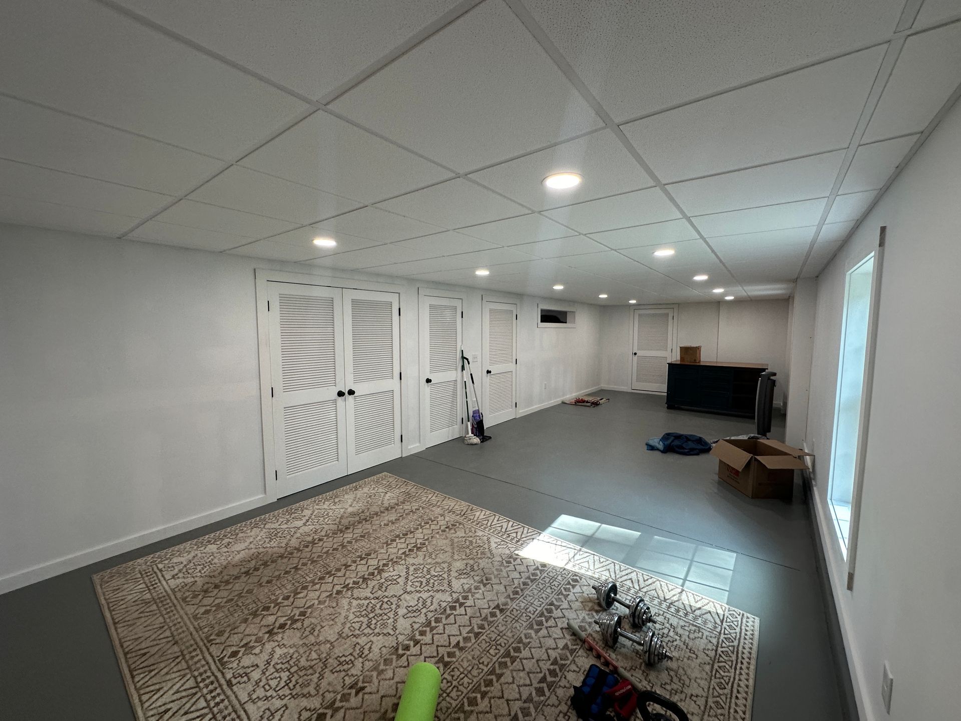 There is a rug on the floor in the middle of the room.