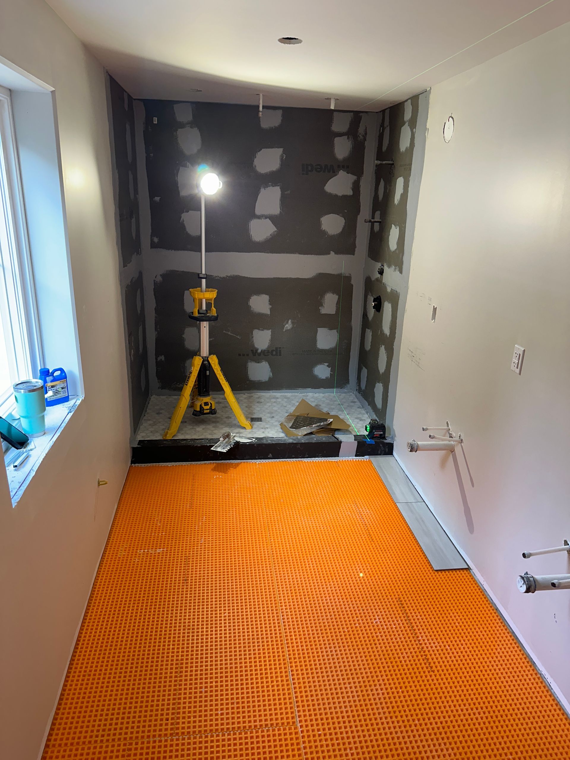 A room with a rug on the floor and a light on the wall.