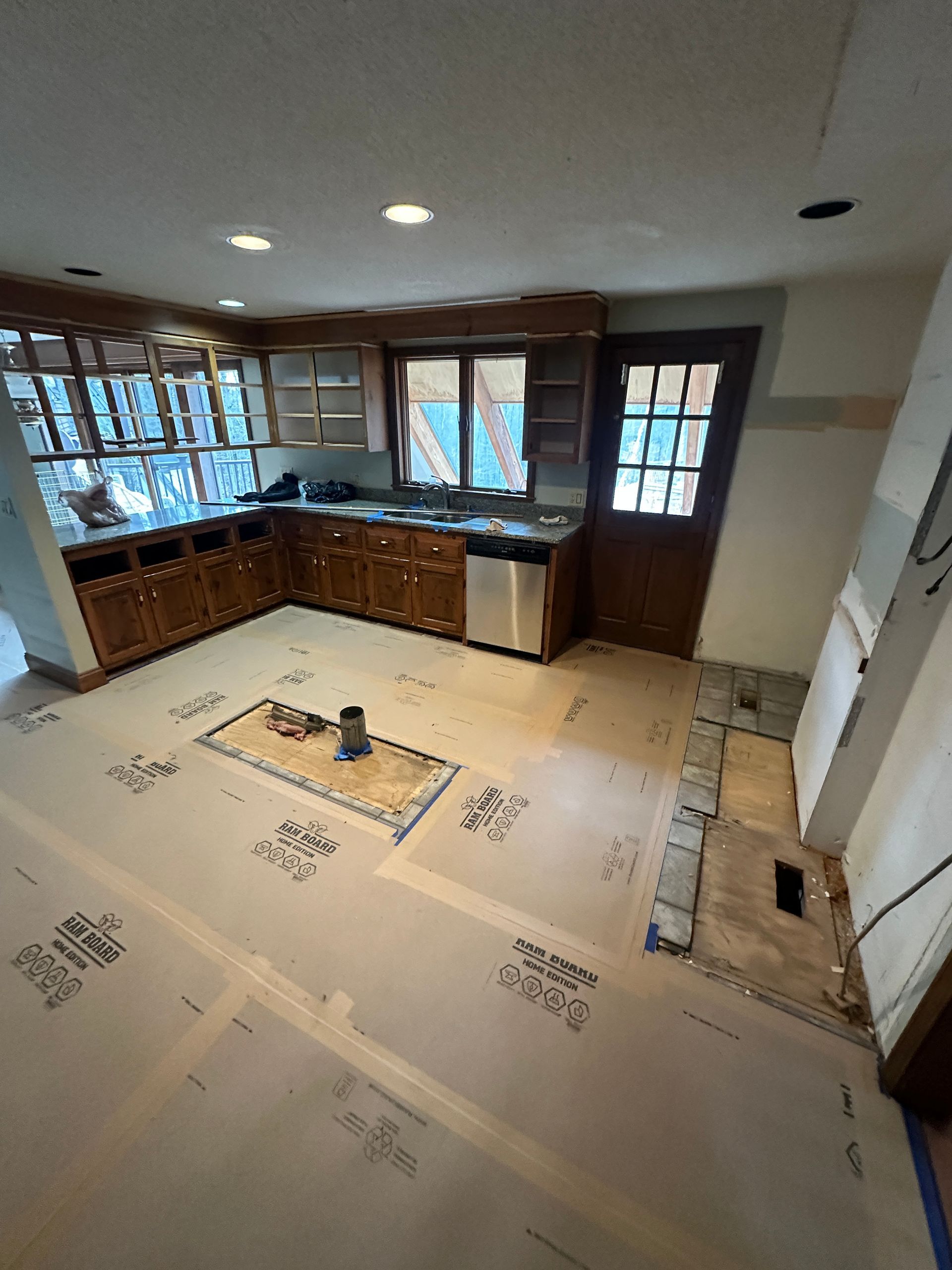 A kitchen with a lot of cabinets and a stainless steel dishwasher.