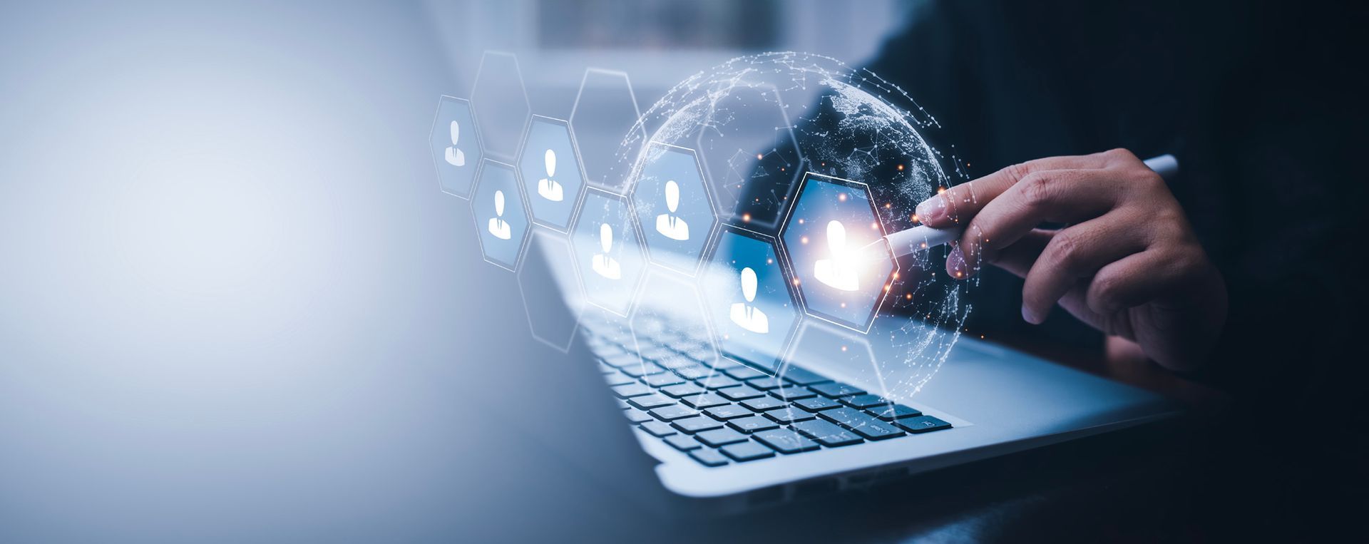 a person is typing on a laptop computer with a globe coming out of it .