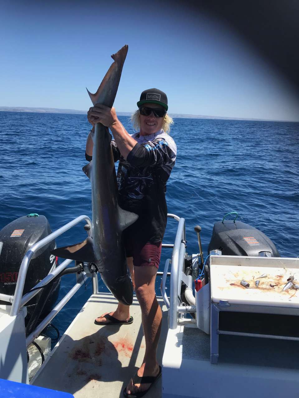 individual on boat holding a big fish