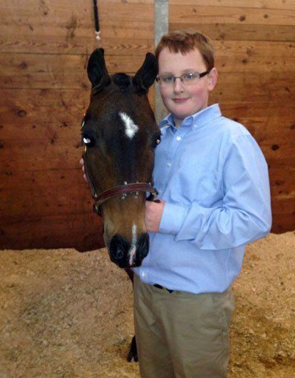 photo of youth in stall holding Hackney Pony