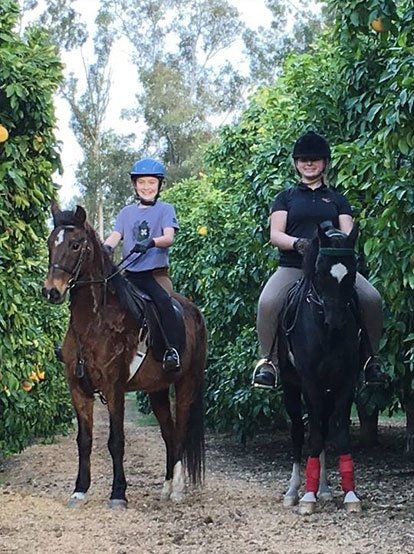 photo of two youth riding Hackney Ponies under saddle on trail