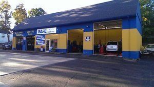 Auto repair shop with blue and yellow exterior, cars in bays.