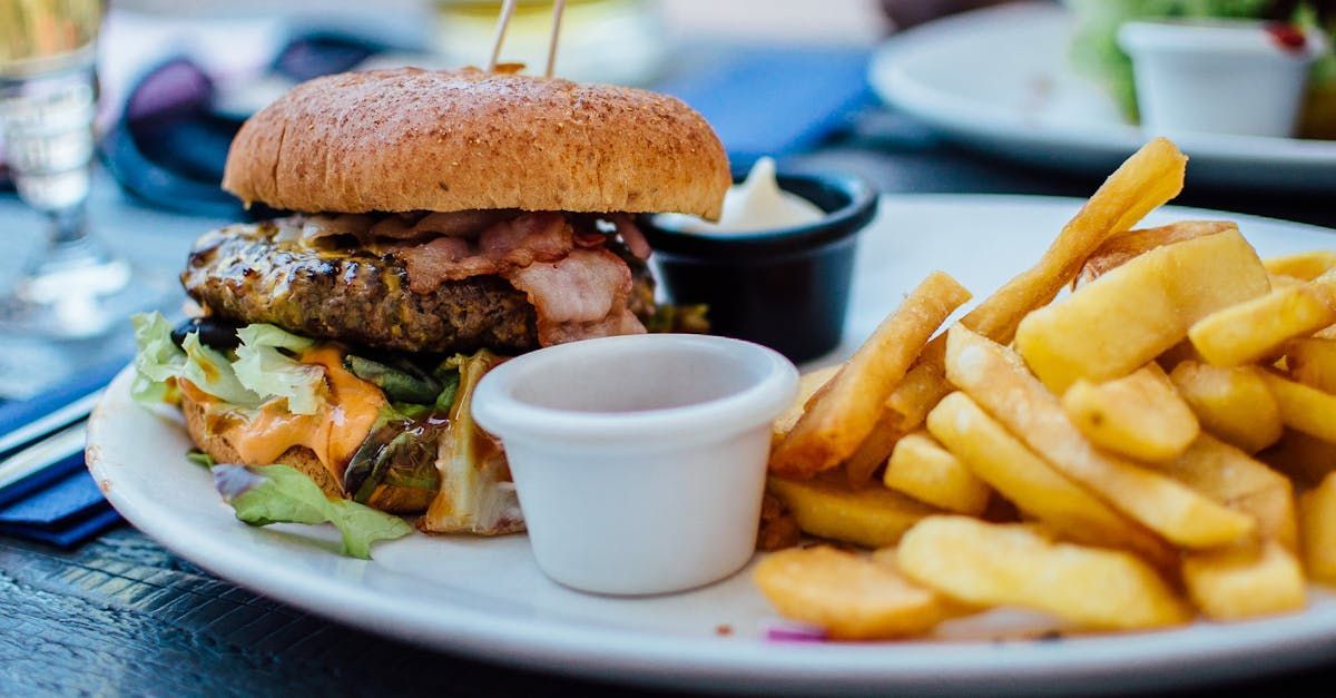 A plate of food with a hamburger and french fries on a table.