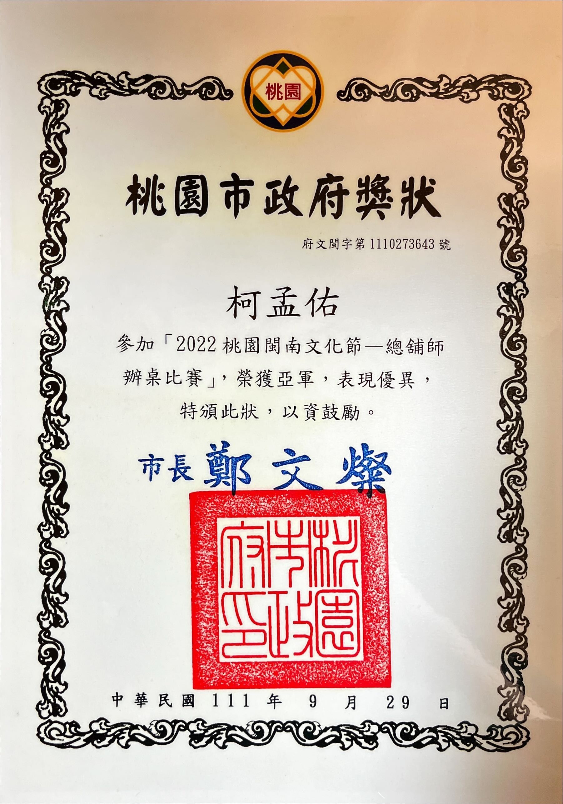 桃園市政府頒發的證書，附有漢字、紅色印章和花卉邊框。