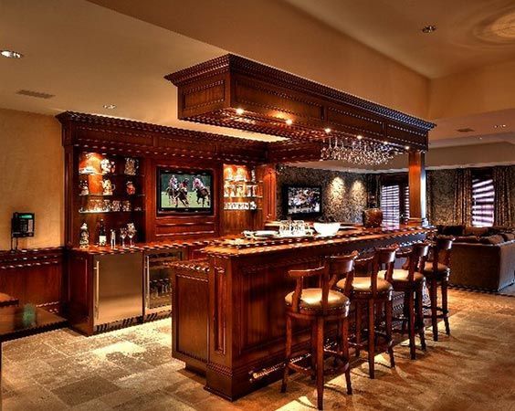 A Home Bar with Stools and A Television on The Wall.