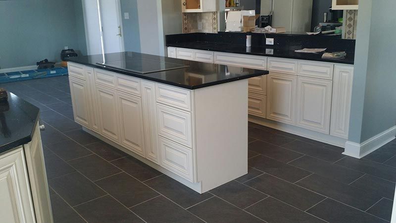 A Kitchen with White Cabinets and Black Granite Counter Tops.