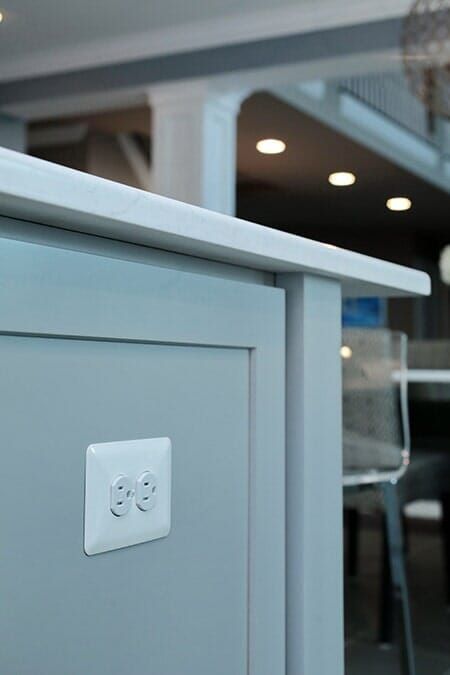 A Close up Of a White Electrical Outlet on A Cabinet in A Kitchen.