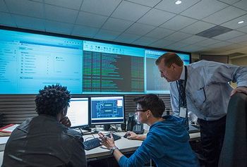 three people looking at monitors