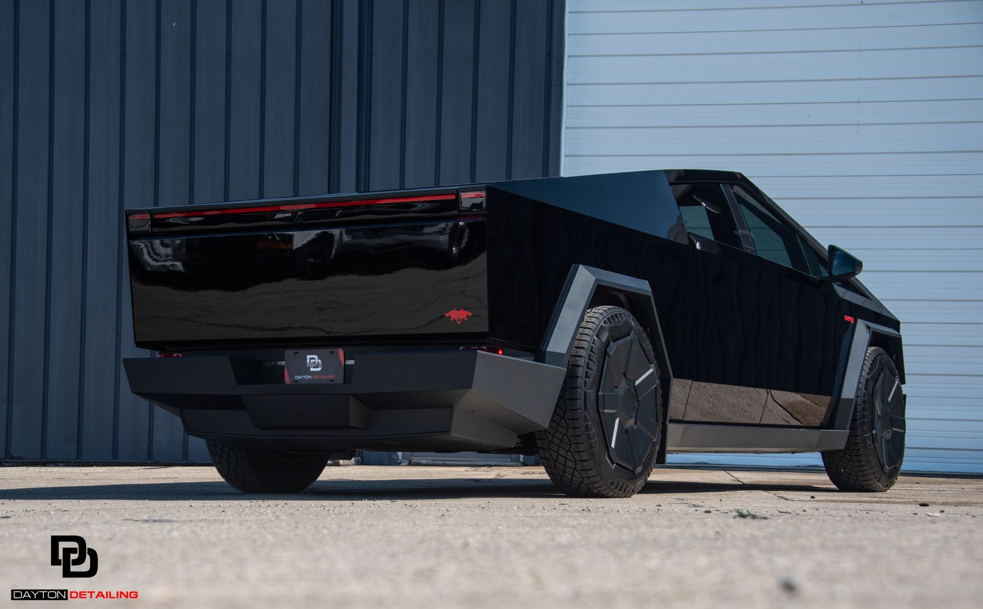 A tesla cybertruck is parked in front of a building.