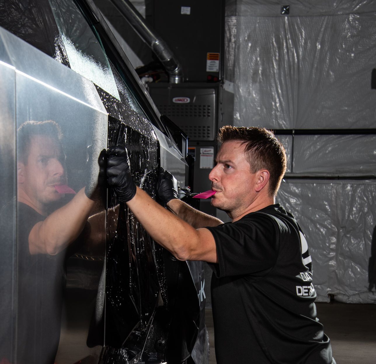 A person is installing ppf the side of a cybertruck with their hands
