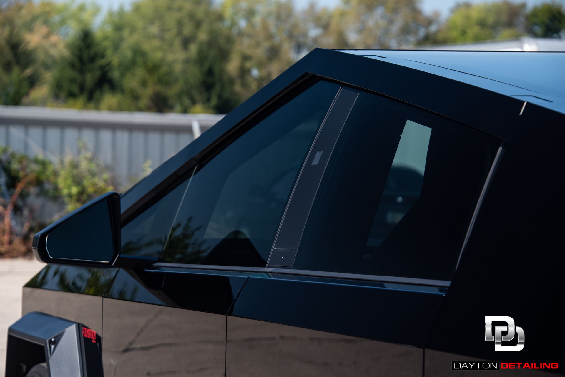 A black car with a tesla logo on the side of it
