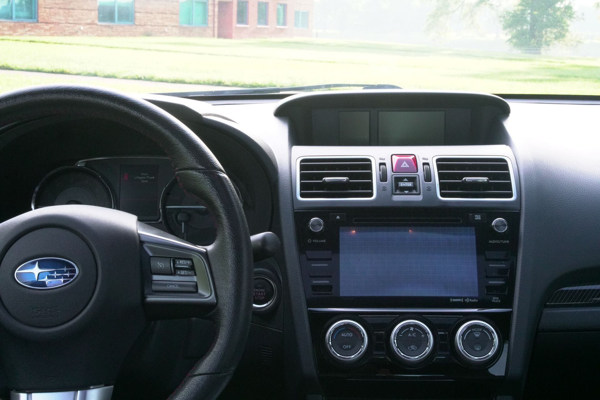 Dashboard of a Subaru car with steering wheel and center console.