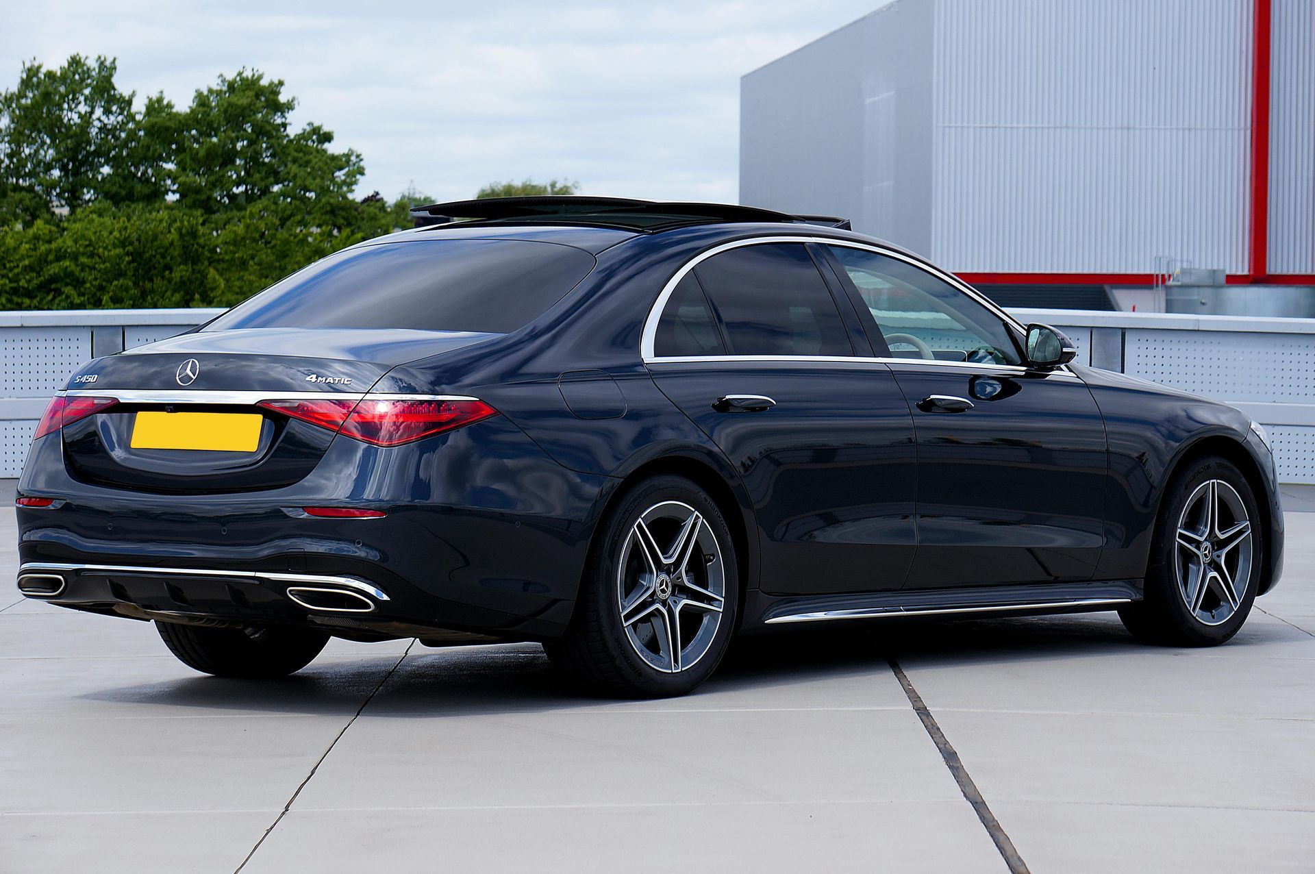 Person applying tint to a car window, using a squeegee tool.