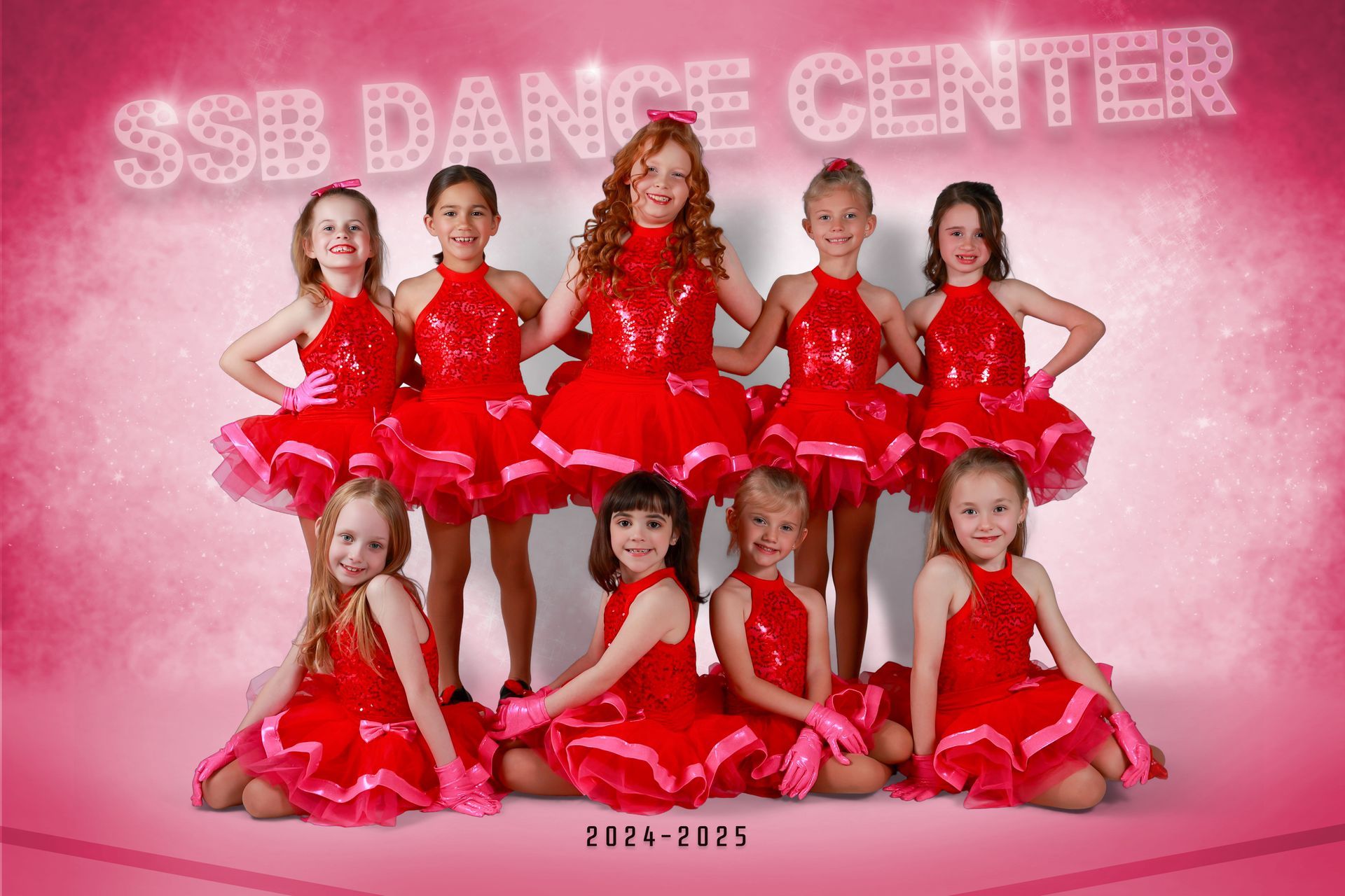 Group of young dancers in red sequin dresses, posing for a studio photo. Pink background and SSB Dance Center text.