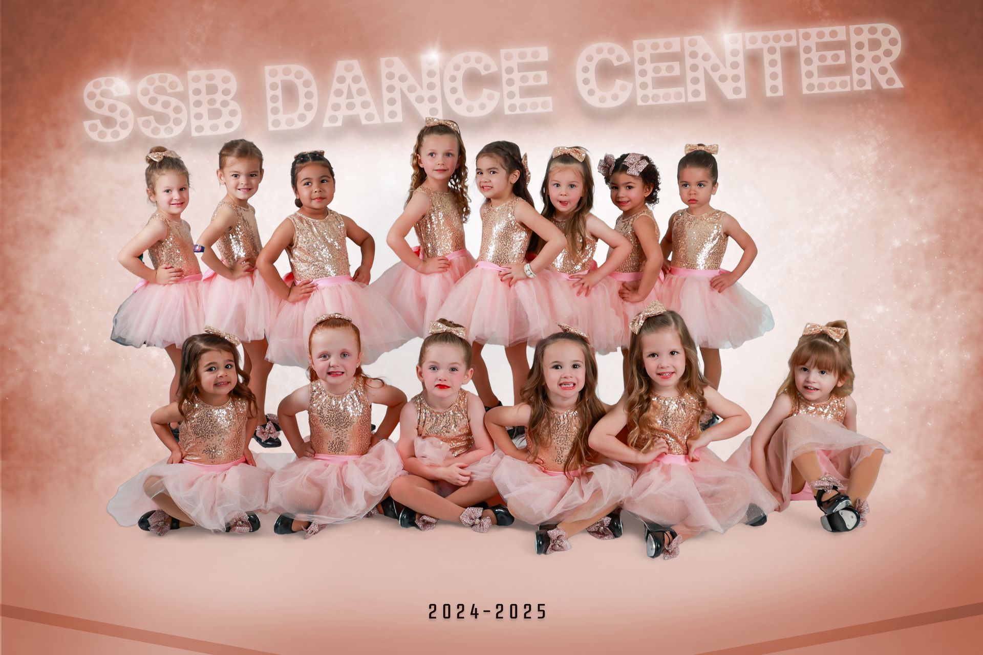 Group of young dancers in pink and gold tutus, posing for a photo. 