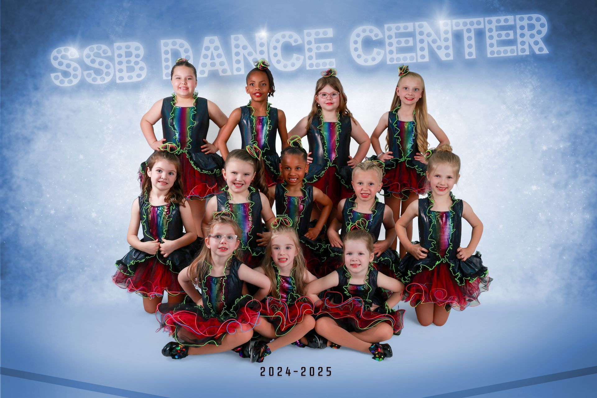Group of young dancers in sparkly costumes posing for a dance center photo.
