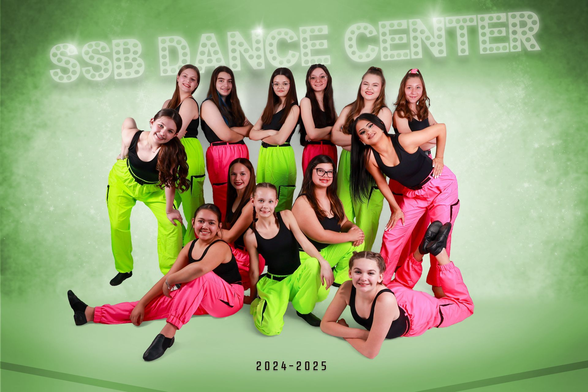 Dance team poses in neon pink and green pants, black tops. 